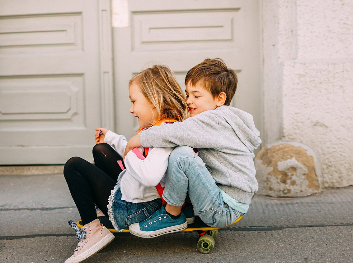 Niño y Niña jugando con el monopatín.
